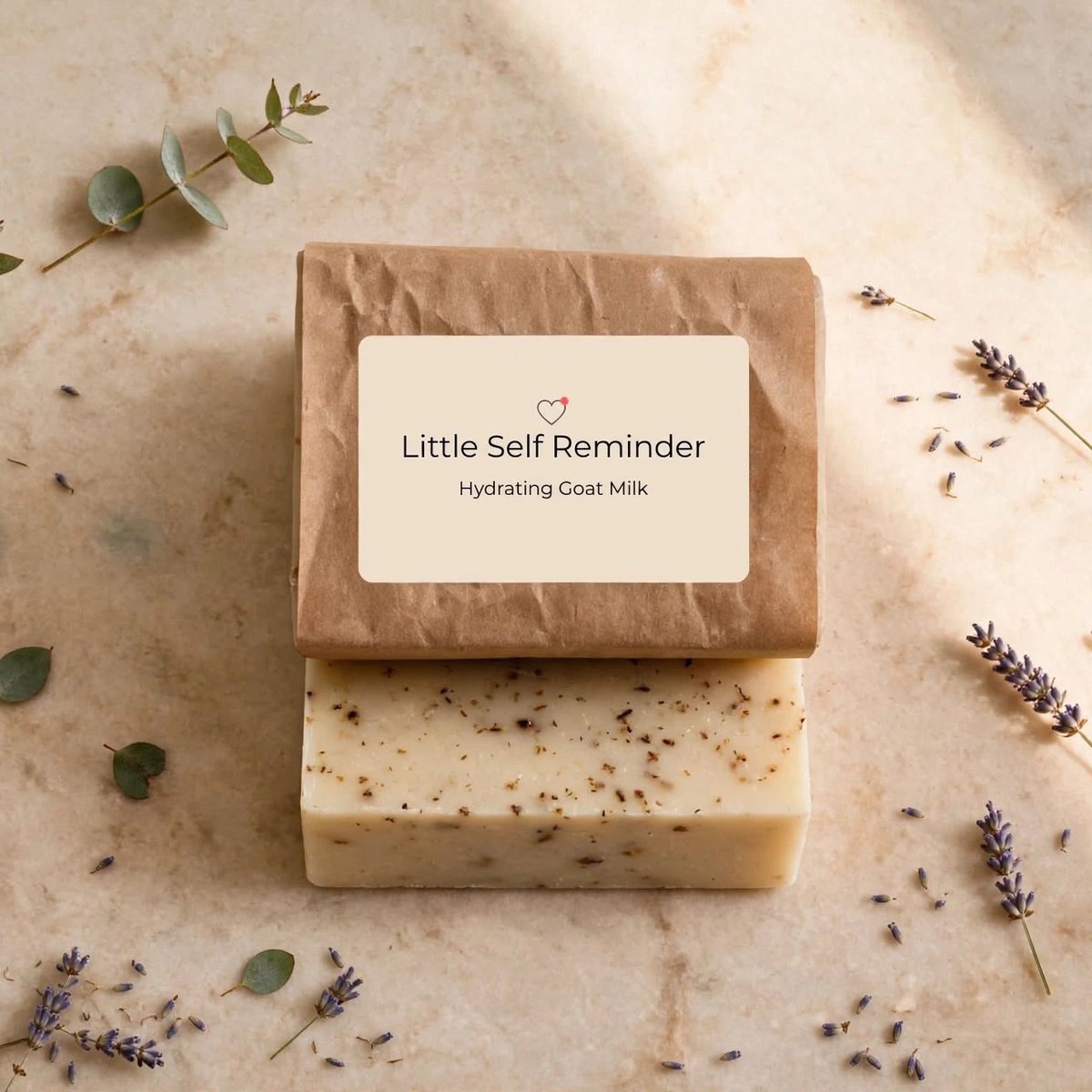 Two stacked handmade soap bars on a light beige stone surface with scattered lavender and eucalyptus sprigs.