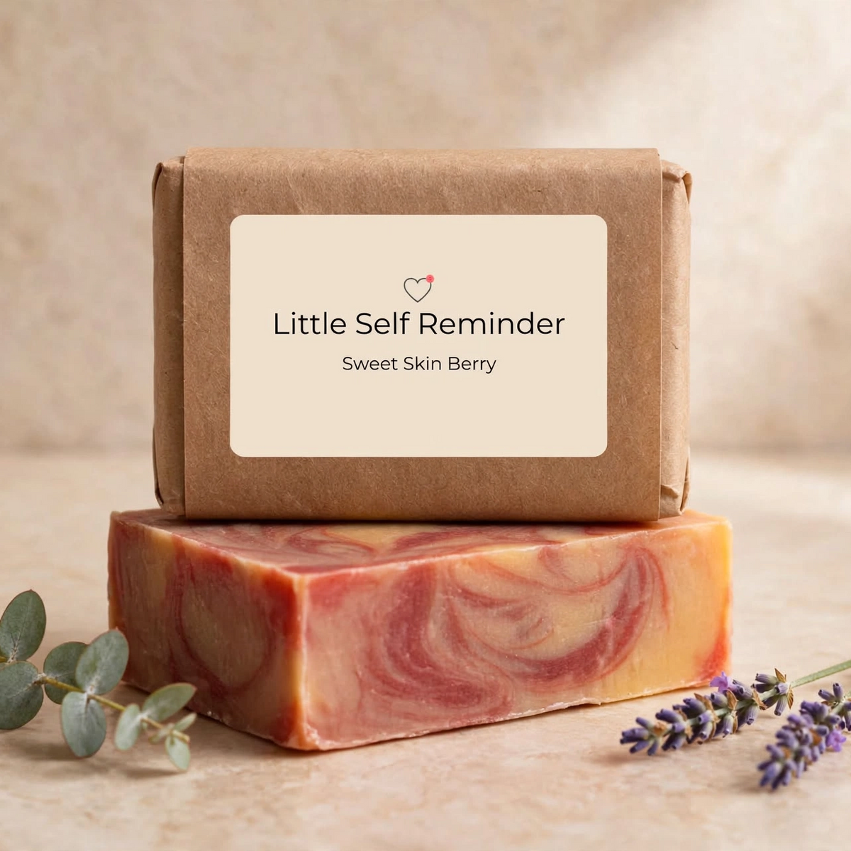 A Kraft paper box labeled 'Little Self Reminder' and 'Sweet Skin Berry' sits on top of a rectangular bar of soap with pink, orange, and cream swirls. 